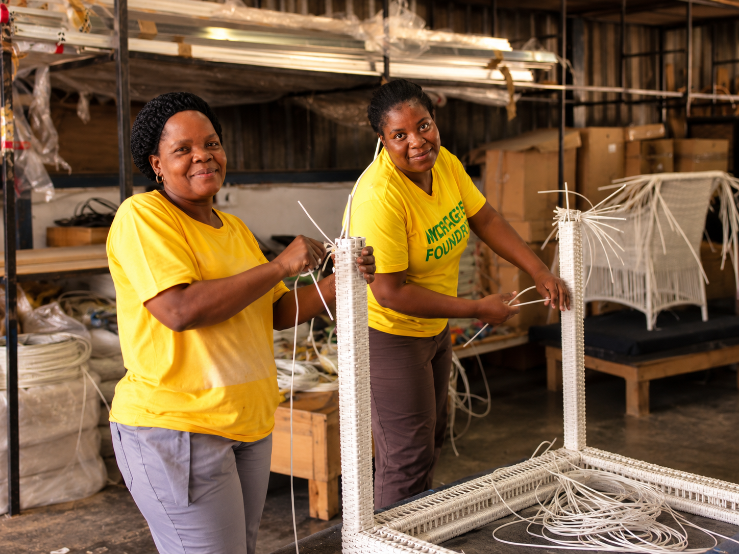 Mirage's weaving team hand-weaving an outdoor table frame in the workshop